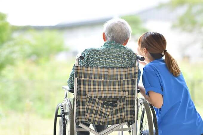 車椅子の男性と介護士の女性