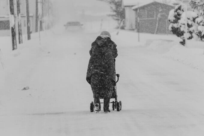 雪道を歩く高齢女性