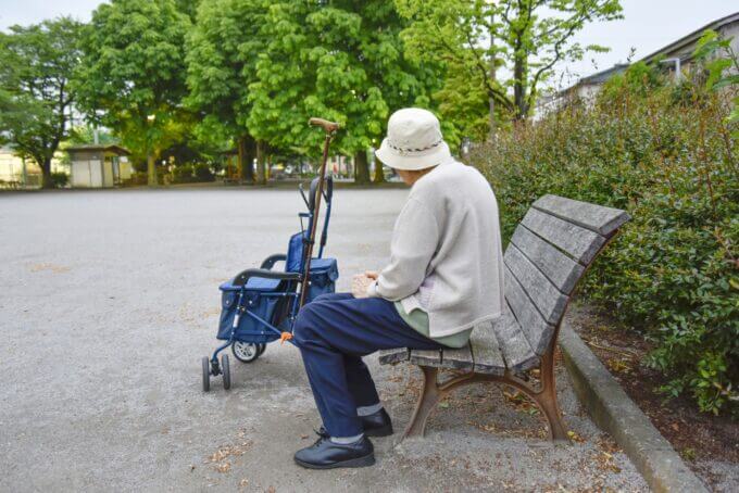 公園のベンチに座る高齢女性